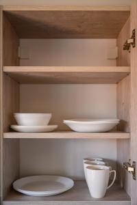 een houten kast met borden en kommen erin bij Beachside Oak Studio in Liepāja