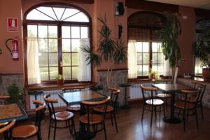 a restaurant with tables and chairs in a room at Hotel Rural LAJAFRIZ in Fornillos de Aliste