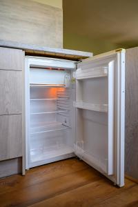 een lege koelkast met de deur open in een keuken bij Beachside Oak Studio in Liepāja