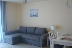 a living room with a blue couch and a table at Apartamento Augusta Cambrils Lux con vista al mar in Cambrils