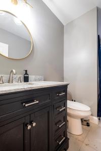 La salle de bains est pourvue d'un lavabo, de toilettes et d'un miroir. dans l'établissement Providence Large, Spacious, Modern 4BR Apartment, à Providence