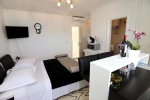 Pokój z łóżkiem i stołem z krzesłami w obiekcie Apartments ITD w Trogirze