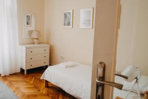 1 dormitorio con cama blanca y vestidor en K2 apartment, en Przemyśl