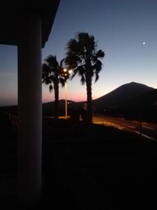 - un coucher de soleil avec des palmiers et une lumière de rue dans l'établissement El sueño - Le rêve, à San Bartolomé