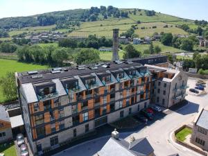 an aerial view of a building with a hill in the background at Horace Mills in Keighley