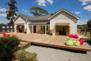 a house with red and green bags on a wooden deck at Waitomo Homestead Cabins in Waitomo Caves