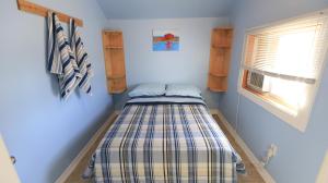 a small bed in a room with a window at Plovers Cove Cottage in Wasaga Beach