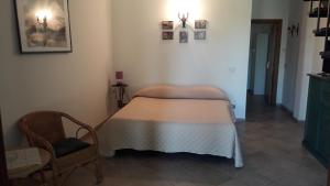 a small room with a bed and a chair at Casale Fonterosa in Montemerano +34 photos