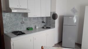 a kitchen with white cabinets and a white refrigerator at Casale Fonterosa in Montemerano