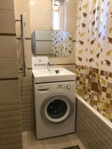 uma máquina de lavar roupa na casa de banho com um espelho em Apartment on Lenina em Adler