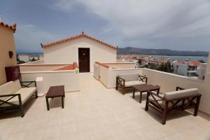 a balcony with chairs and tables on a building at Berdoussis Hotel in Elafonisos