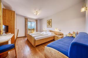 a bedroom with two beds and a television in it at Hotel Stefanie in Tirolo