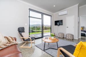 a living room with a couch and a table at Northcoast Getaway in Mangawhai