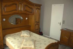 a bedroom with a wooden bed with a wooden headboard at Bel petit appartement in Charleville-Mézières +2 photos