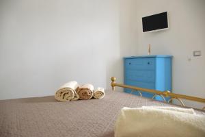 una camera da letto con un letto con asciugamani e un comò blu di BnB Le Janas a Càbras