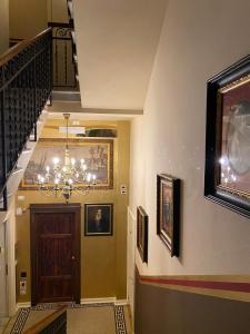 a hallway with a staircase leading to a room with a clock on the wall at Villa Tower Inn in Pisa