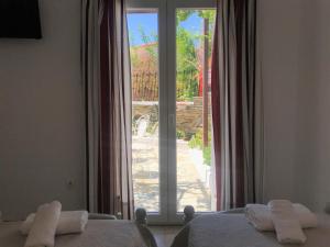 a bedroom with a large window with towels on the beds at Danaides Studios in Batsi