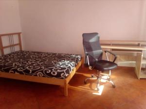 een slaapkamer met een bureau en een stoel naast een bed bij Rooms in the apartment-center in Košice
