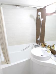 a white bathroom with a sink and a toilet at Niigata Station Hotel in Niigata
