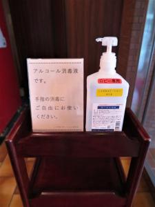 a bottle of mouthwash and a box on a wooden stand at Niigata Station Hotel in Niigata