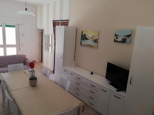 Una sala de estar con una mesa y un televisor. en Casa Uccio, en San Pietro in Bevagna