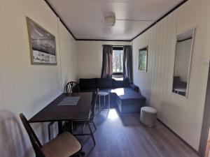 a small living room with a table and a couch at Tommerneset Camping in Innhavet