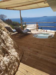 a patio with a hot tub and chairs on a deck at Mandalina Suites in Kaş