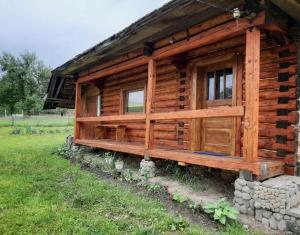a log cabin with windows on the side of it at Затишна хата in Huklyvyy