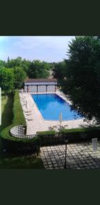 une grande piscine avec des chaises et un pavillon dans l'établissement Parador de Manzanares, à Manzanares