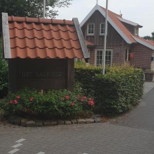 un bâtiment avec un panneau devant une maison dans l'établissement BGLV, à Hoge-Hexel
