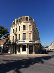 an old building on the corner of a street at Hôtel La Couronne in Marmande