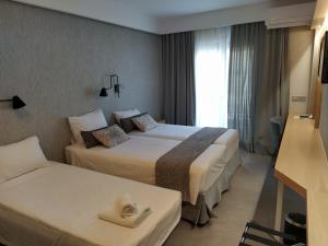 Postel nebo postele na pokoji v ubytování Minoa Hotel