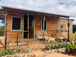 ein Holzhaus mit einer Bank davor in der Unterkunft GuaiGüí Bayahibe in Bayahibe