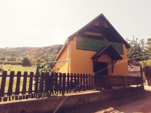 une petite maison avec une clôture devant elle dans l'établissement Kádárok Vendégháza a Somló-hegyen, à Somlószőlős