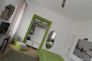 a living room with a green mirror and a couch at Casa Griot in Trieste