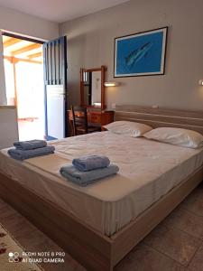 a bedroom with a large bed with towels on it at Vias in Neapoli Voion