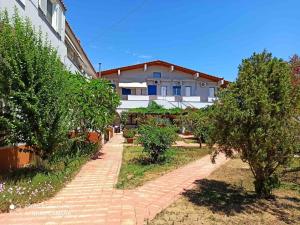 a brick walkway in front of a building with trees at Vias in Neapolis