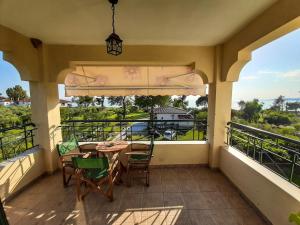 a balcony with a table and chairs and a view at Sapfo Beach Studios in Nikiti