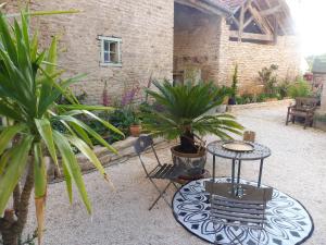 un patio con mesa, sillas y plantas en Chambre d'hôtes des 3 ifs en Vernot