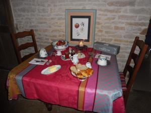 une table avec une nappe rose et un bol de nourriture dans l'établissement Chambre d'hôtes des 3 ifs, à Vernot