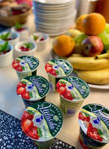 a table with cups of yogurt with strawberries and fruit at Hotel Rustikal in Horní Cerekev