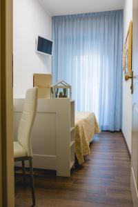 ベッラーリア・イジェア・マリーナにあるHotel Augustaのベッドルーム1室(ベッド1台、椅子、テーブル付)