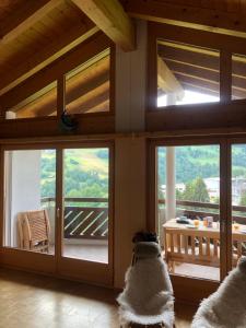 a dog sitting in a room with sliding glass doors at Casa Spel Mir in Disentis
