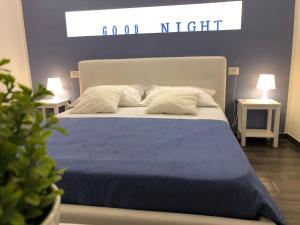 ein Bett mit einer blauen Decke und Kissen darauf in der Unterkunft CIVICO 29 in Pompei