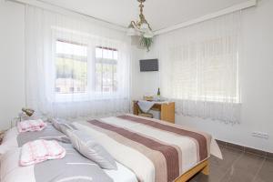 a bedroom with a bed and two windows at Penzion U Králíků in Kurdějov