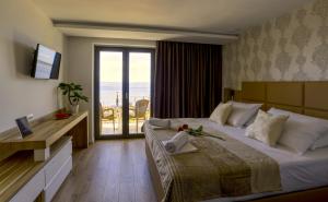 a hotel room with a bed and a large window at Villa Lenka and Mate Ivanac in Brela