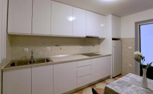 a kitchen with white cabinets and a sink and a table at Villa Lenka and Mate Ivanac in Brela +97 photos