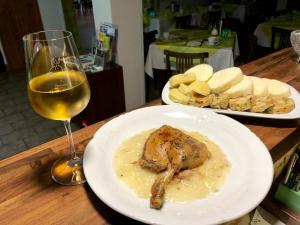 a table with two plates of food and a glass of wine at Penzion U Králíků in Kurdějov