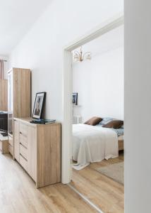 - une chambre blanche avec un lit et un miroir dans l'établissement Apartament Poznańska, à Varsovie
