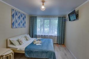 a bedroom with a bed and a tv and a window at YourHouse микрорайон 1, дом 76 - экономичнее квартиры, уютнее гостиницы in Almaty